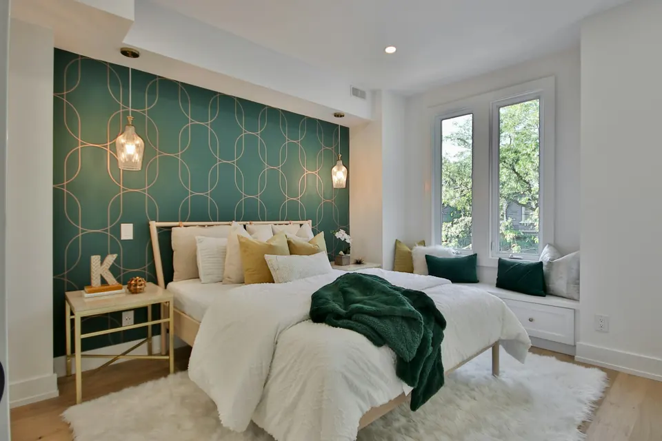 Slaapkamer met een behangen accentwand in groen met een fijn patroon